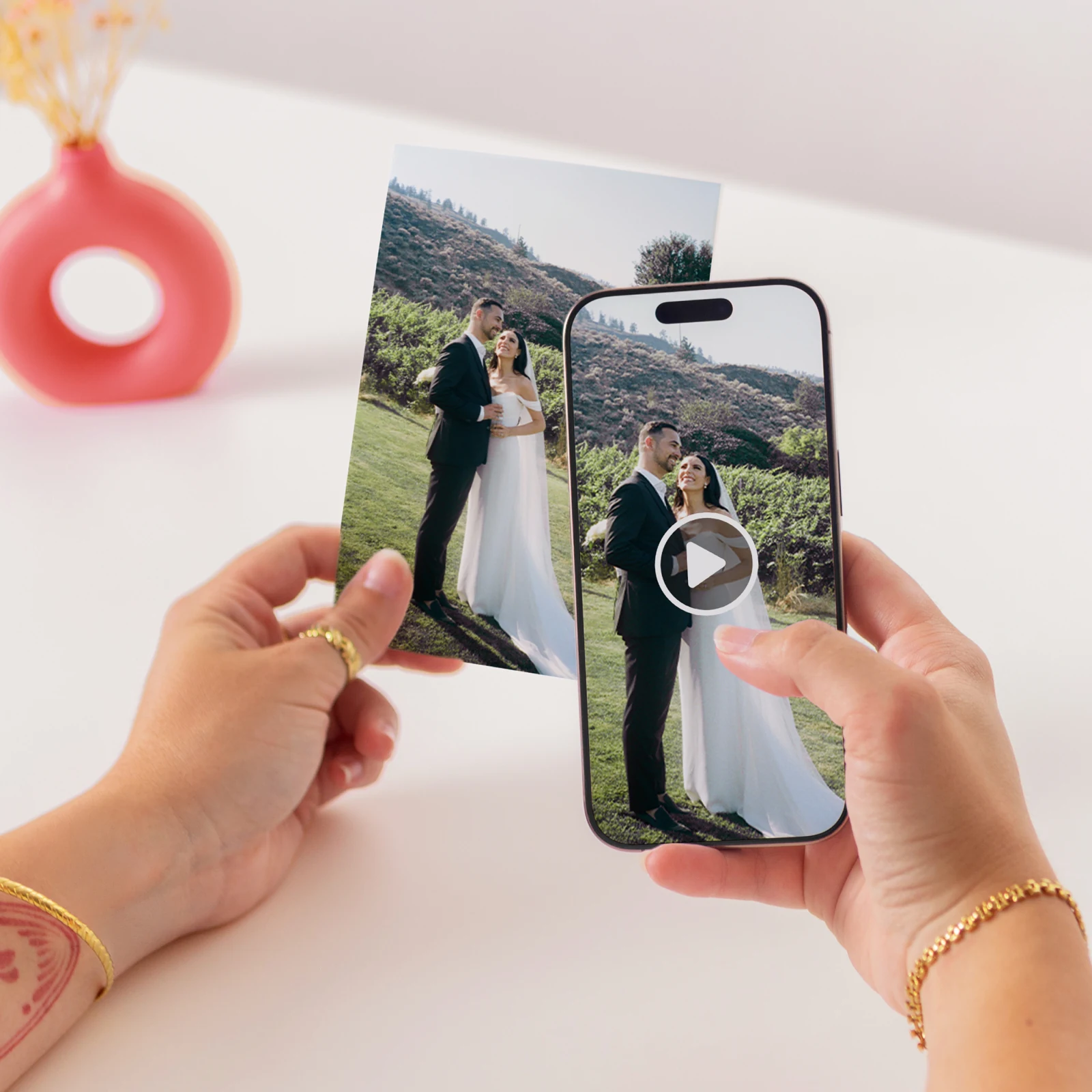 A printed wedding photo beside a phone playing the video back