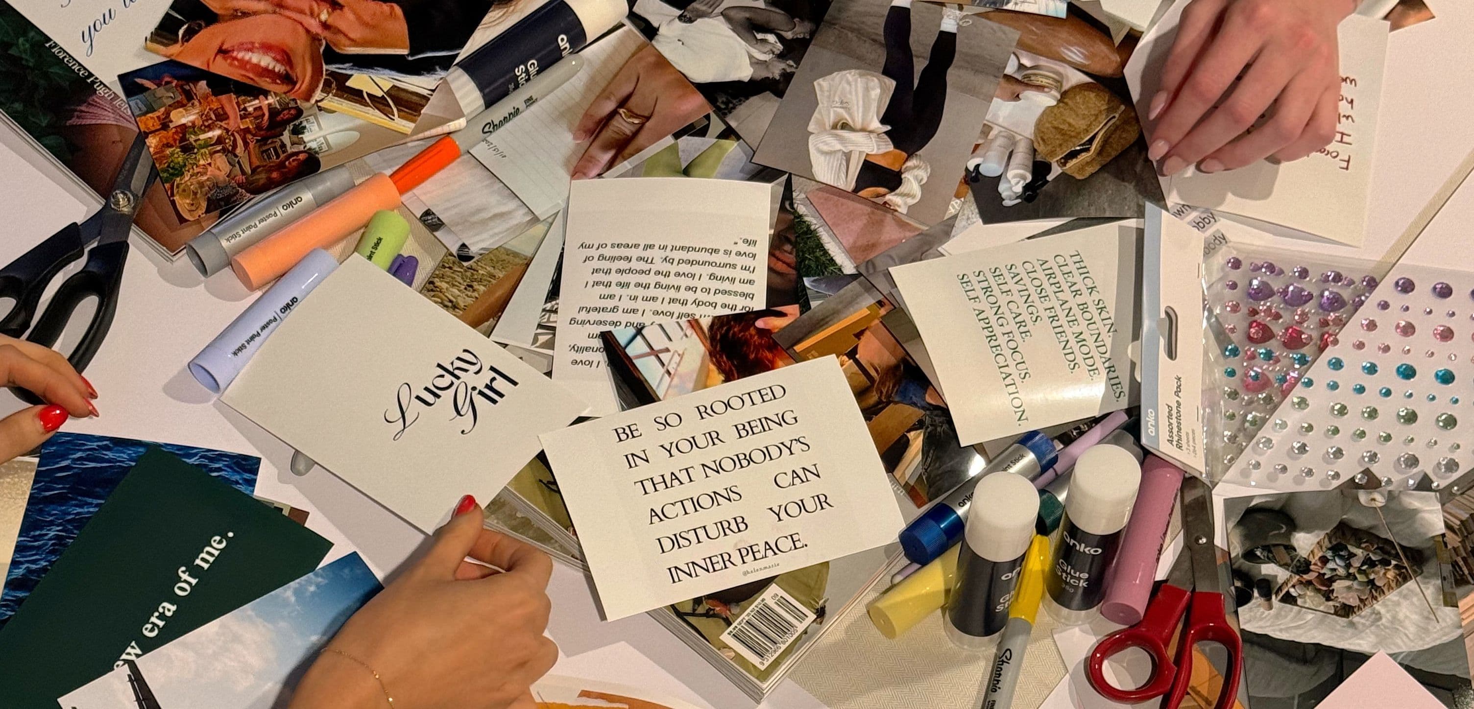 Table covered with quotes, pictures, pens, and other craft supplies