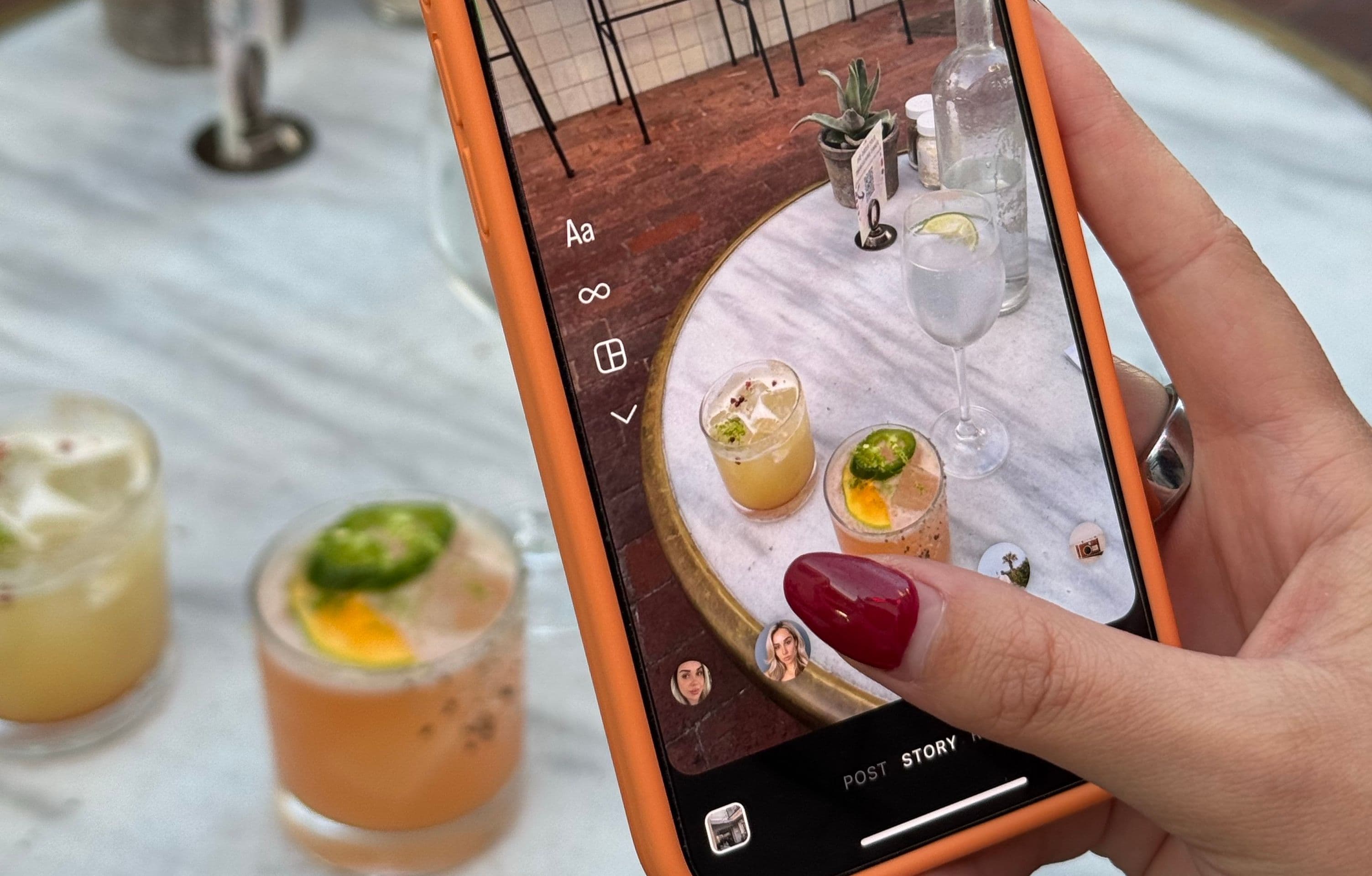 Phone taking a picture of a table with cocktails