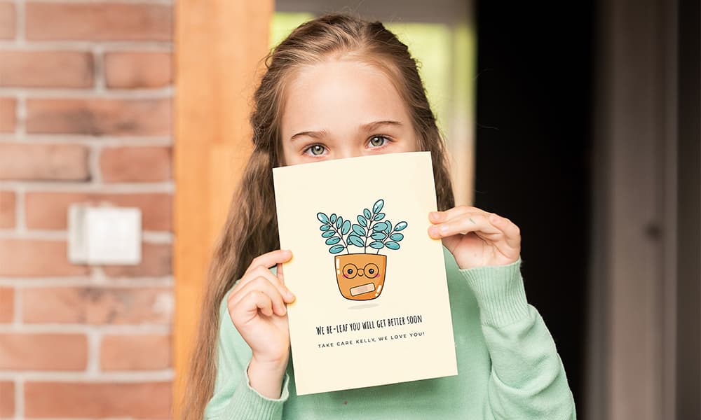 young girl holding a get well soon card